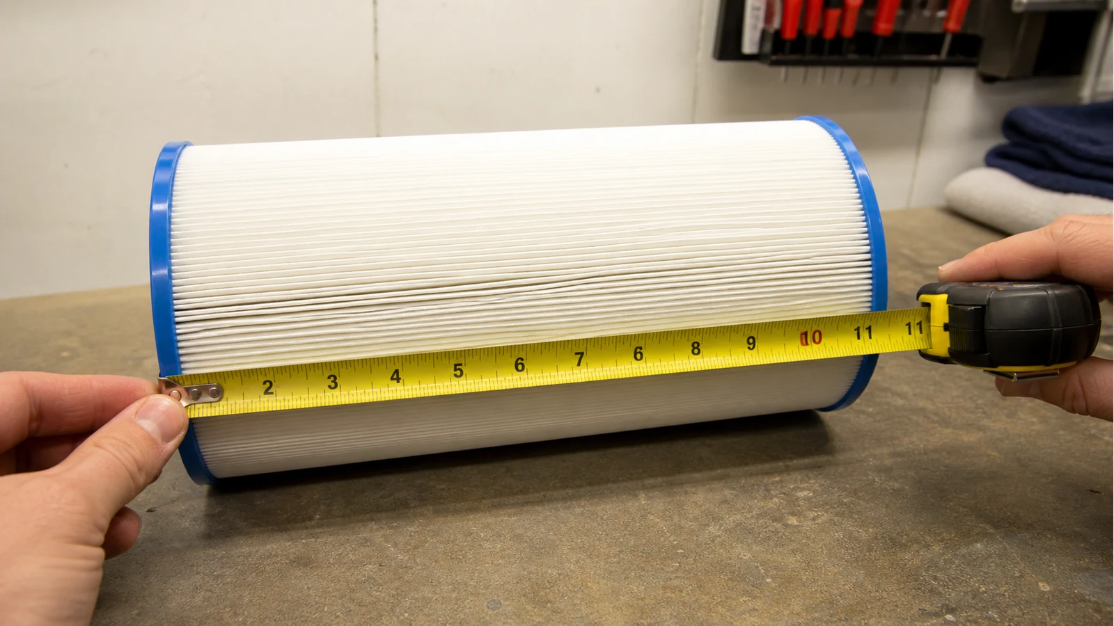 Measuring the length of a pleated hot tub filter cartridge with a tape measure